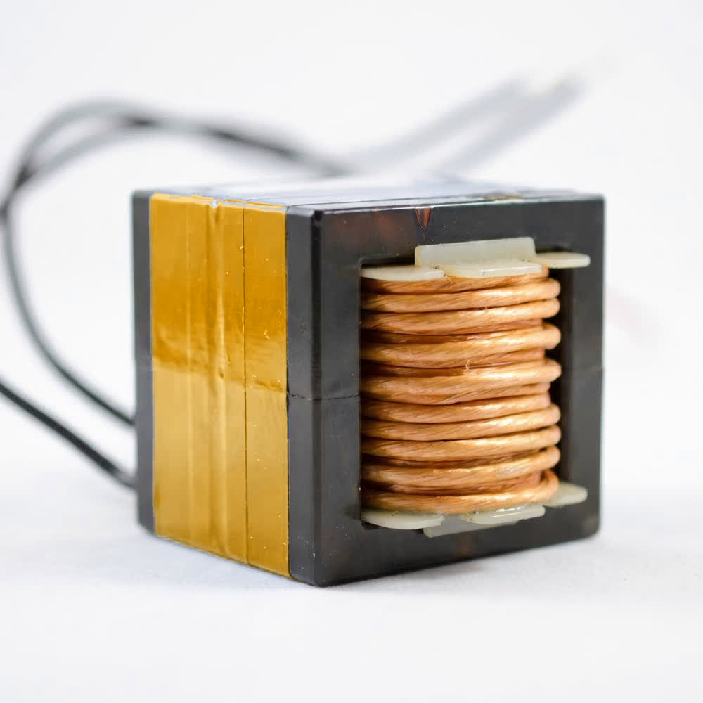 A heavy copper winding filling the window of a taped core